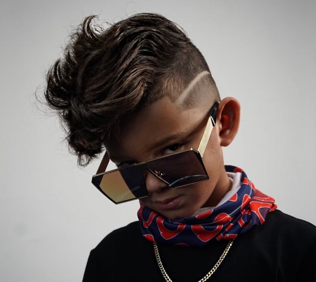 A young client showing a styled cut with a shaved design line